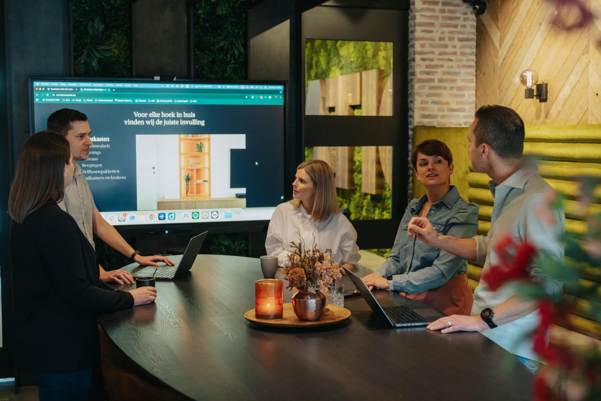 Team bespreekt website strategie en online oplossingen op scherm