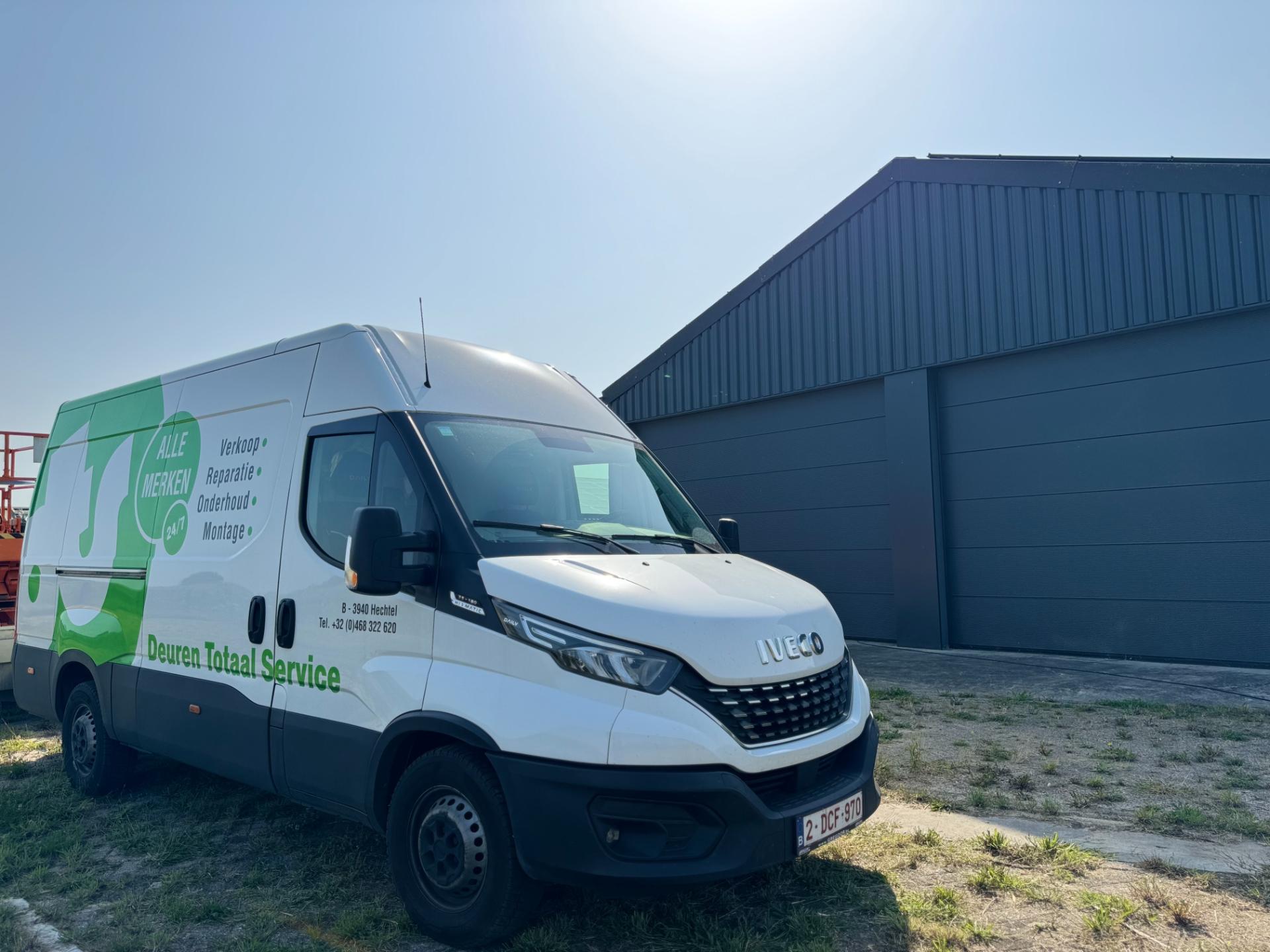 Bestelwagen van Deuren Totaal Service aan een loods