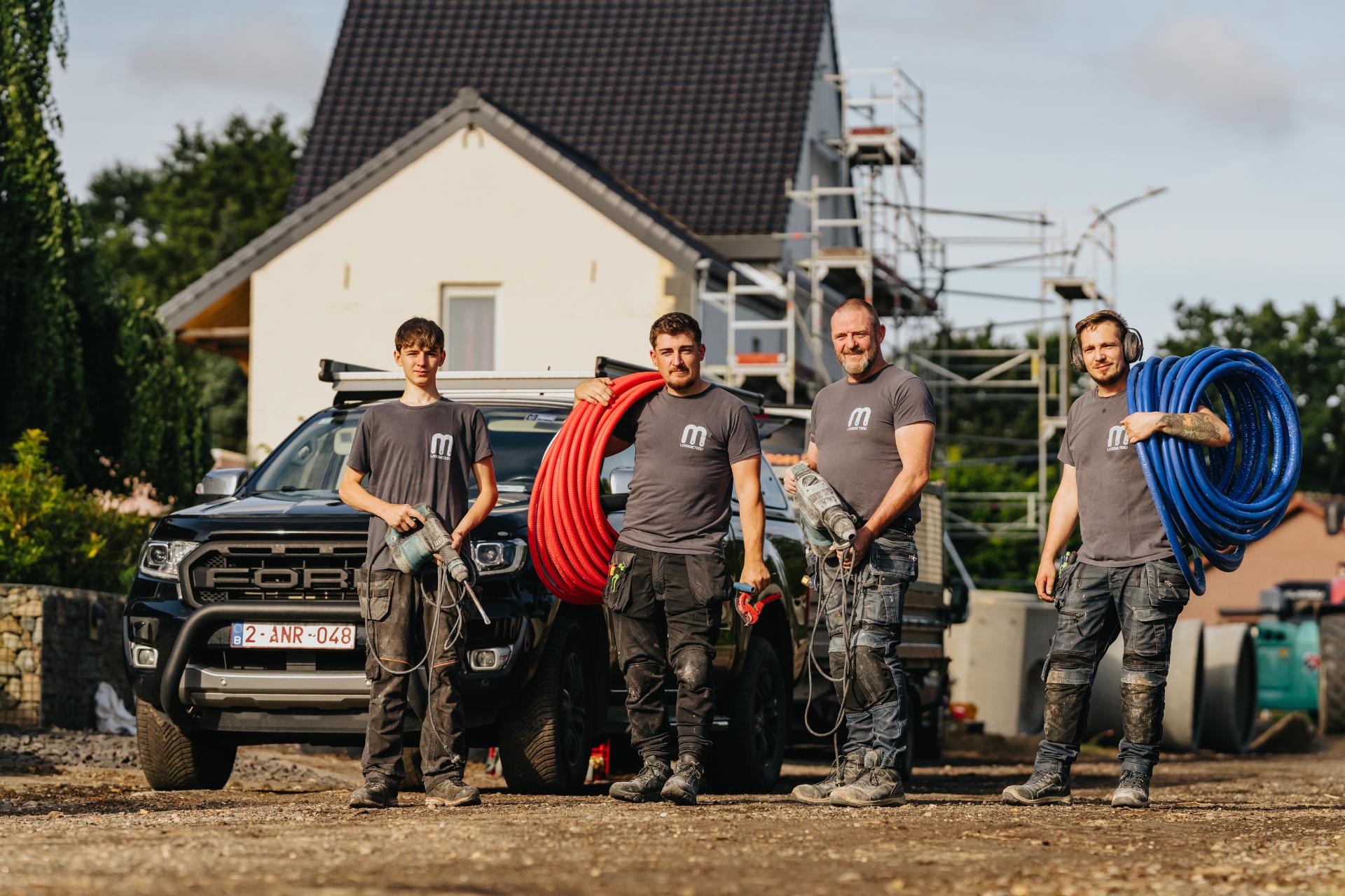 Het team van Loodgieterij Maes bij hun bestelwagen aan een werf
