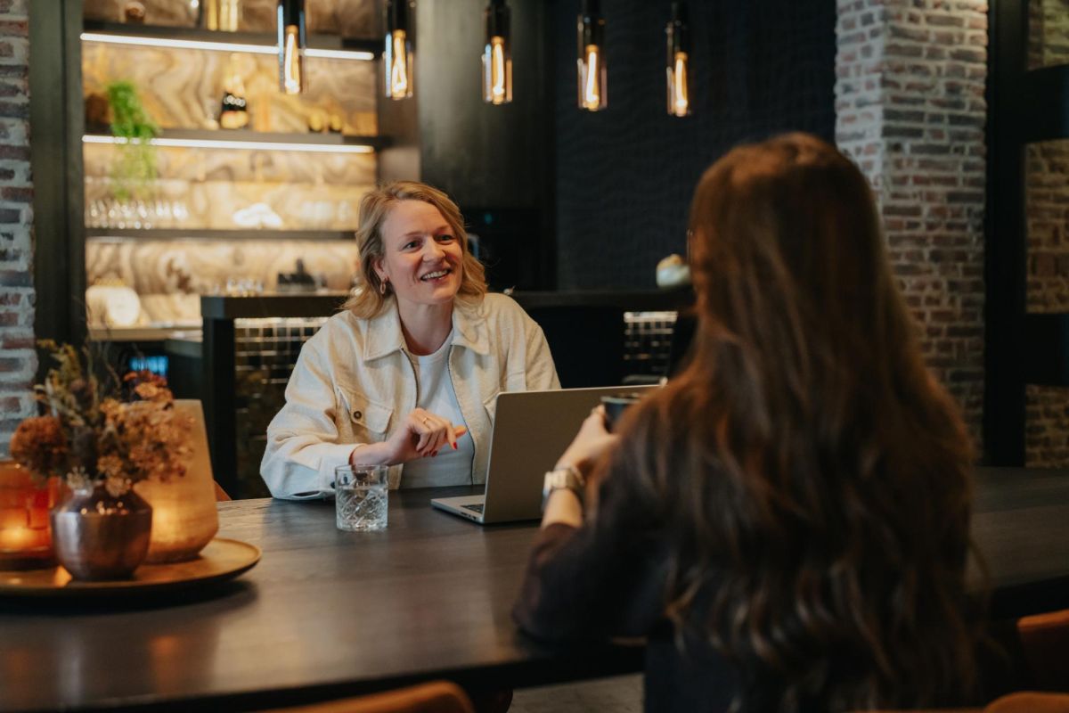 Lachend gesprek met een klant aan tafel